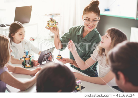 Pleased woman and kids playing with gadget 41169124