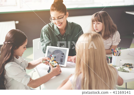 Positive teacher and children creating toy Positive teacher and children creating toy 41169141