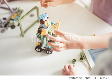 Kids arms creating robot from constructor 41169472