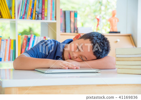 Young schoolboy fall asleep in school library Young schoolboy fall asleep in school library 41169836