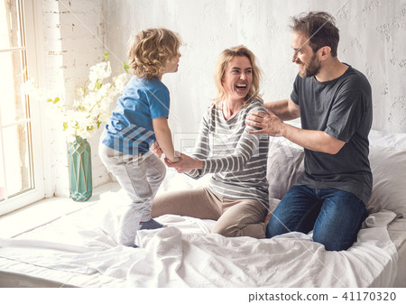 Smiling family is sharing joyous moment together in bedroom 41170320