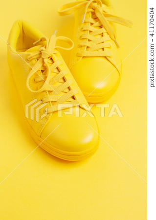 Pair of yellow shoes on yellow background. Pair of yellow shoes on yellow background. 41170404