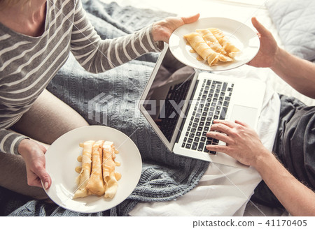 Male is having breakfast while exploiting laptop 41170405