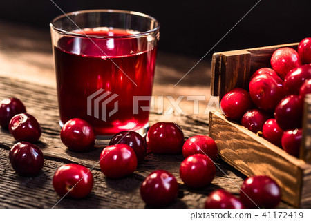 Fresh cherries in a wooden box and cherry juice Fresh cherries in a wooden box and cherry juice 41172419
