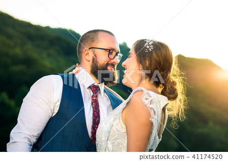 Bride and groom hugging at romantic sunset Bride and groom hugging at romantic sunset 41174520