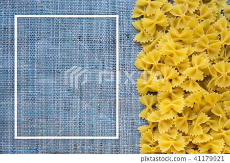 farfalle macaroni Beautiful decomposed pasta with the right, on its side on a rustic blue knitted farfalle macaroni Beautiful decomposed pasta with the right, on its side on a rustic blue knitted 41179921