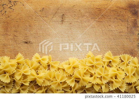 farfalle macaroni Beautiful decomposed pasta with a bottom on a wooden plank texture background farfalle macaroni Beautiful decomposed pasta with a bottom on a wooden plank texture background 41180025