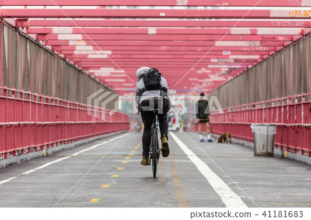 Man riding his bike in the cycling lane on Williamsburg Bridge, Brooklyn, New York City. 41181683