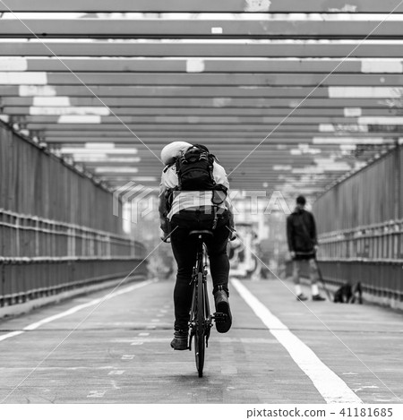Man riding his bike in the cycling lane on Williamsburg Bridge, Brooklyn, New York City. 41181685