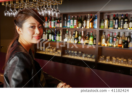 Adult woman sitting in a bar counter Adult woman sitting in a bar counter 41182424