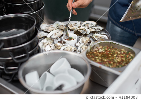 Close Up Server with Tray of Fresh Shucked Oysters Close Up Server with Tray of Fresh Shucked Oysters 41184008