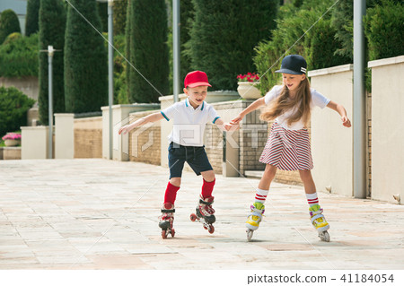 Portrait of a charming teenage couple roller-skating together Portrait of a charming teenage couple roller-skating together 41184054