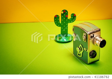 background with an old camera and a toy cactus background with an old camera and a toy cactus 41186782