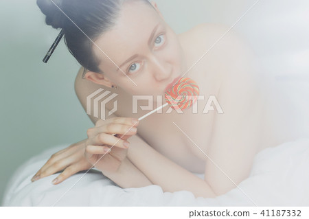 Alluring nude woman licking lollipop 41187332