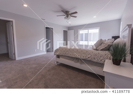 A bright sliding glass door sits behind the bed A bright sliding glass door sits behind the bed 41189778