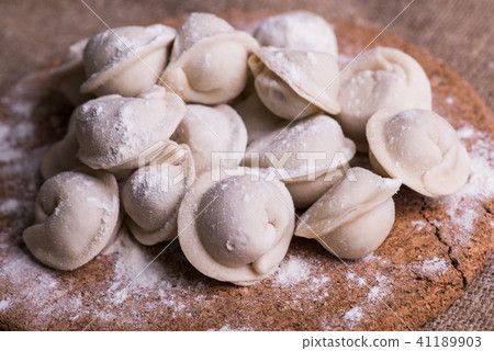 Uncooked dumplings Pelmeni. Traditional Russian dish. Background from pelmeni laid out on a chopping 41189903