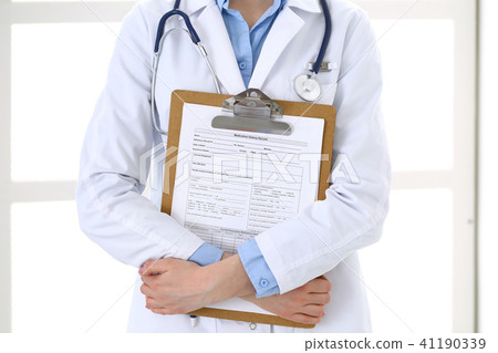 Female doctor filling up medical form on clipboard closeup. Healthcare, insurance and medicine Female doctor filling up medical form on clipboard closeup. Healthcare, insurance and medicine 41190339