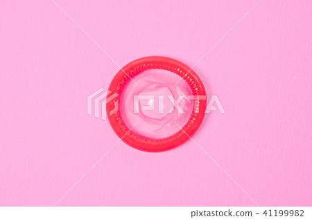 Opened condom on pink background. Opened condom on pink background. 41199982