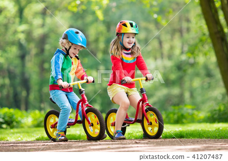 Kids ride balance bike in park 41207487