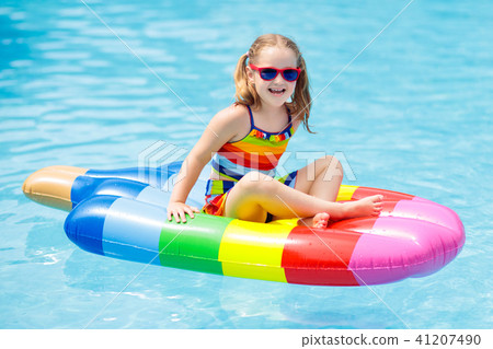Child on inflatable float in swimming pool. Child on inflatable float in swimming pool. 41207490