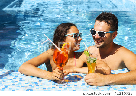 Young couple are relaxing in swimming pool Young couple are relaxing in swimming pool 41210723
