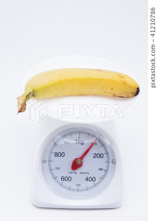 Bunch of bananas on scales isolated on white 41210786