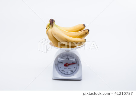 Bunch of bananas on scales isolated on white 41210787