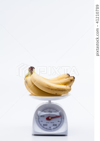 Bunch of bananas on scales isolated on white Bunch of bananas on scales isolated on white 41210789
