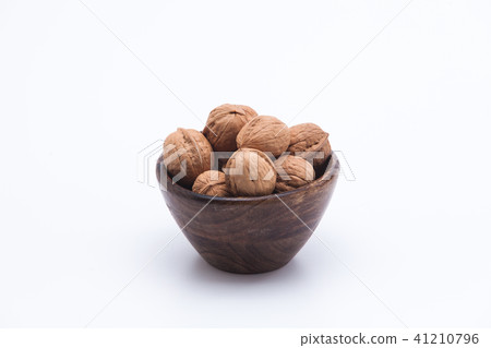 Walnuts in wooden bowl isolated on white backgroun Walnuts in wooden bowl isolated on white backgroun 41210796