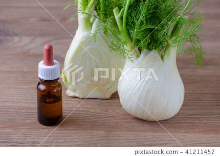 fennel essential oil and bulb on brown wooden background 41211457