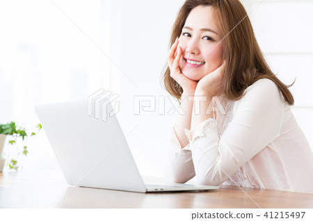 觀看一台便攜式計算機的婦女在屋子裡 觀看一台便攜式計算機的婦女在屋子裡 41215497