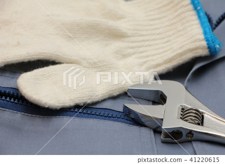 Gloves and monkey wrench placed on blue working clothes Gloves and monkey wrench placed on blue working clothes 41220615