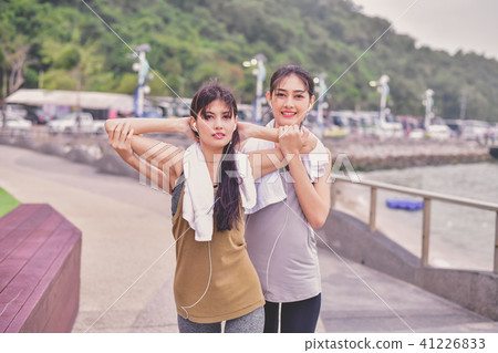 Sports concept. Beautiful girl is exercising on the beach with w Sports concept. Beautiful girl is exercising on the beach with w 41226833