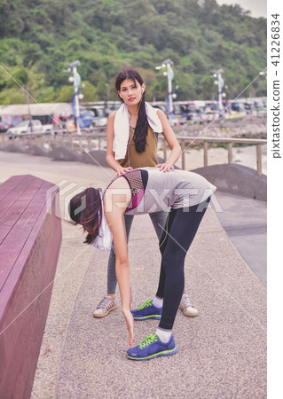 Sports concept. Beautiful girl is exercising on the beach with w 41226834