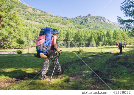 Young woman hiker on a sunny day trekking in high mountains Young woman hiker on a sunny day trekking in high mountains 41229032