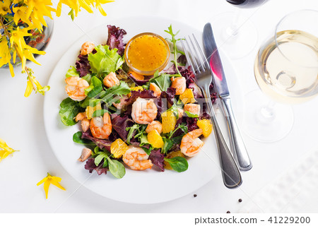 Healthy salad with prawns, lettuce, oranges and mango served on a plate with orange mustard sauce Healthy salad with prawns, lettuce, oranges and mango served on a plate with orange mustard sauce 41229200