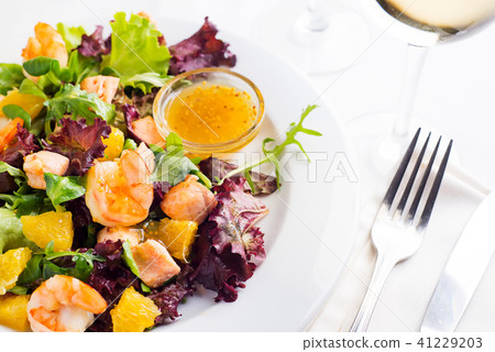 Healthy salad with prawns, lettuce, oranges and mango served on a plate with orange mustard sauce Healthy salad with prawns, lettuce, oranges and mango served on a plate with orange mustard sauce 41229203