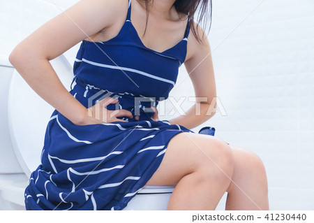 Woman sitting on toilet with diarrhea 41230440