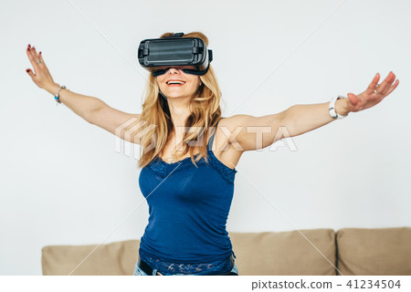 Woman at home using virtual reality headset 41234504