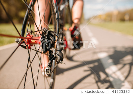 Cyclist on bike path, view from the rear wheel 41235383