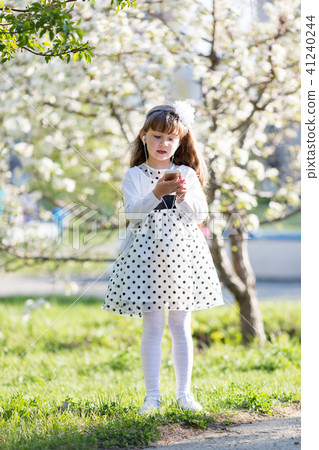 The girl listens to music from her mobile phone. 41240244