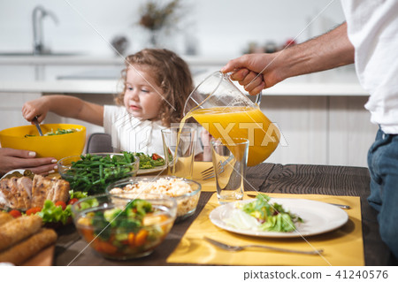 Cheerful dad serving healthy drink for his daughter  41240576