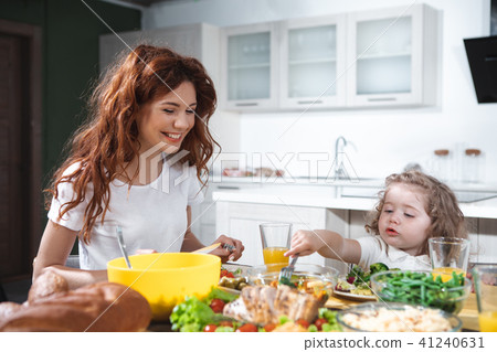 Joyful mother and daughter enjoying healthy dinner together Joyful mother and daughter enjoying healthy dinner together 41240631