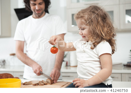 Curious female child staring at vegetable in kitchen Curious female child staring at vegetable in kitchen 41240750