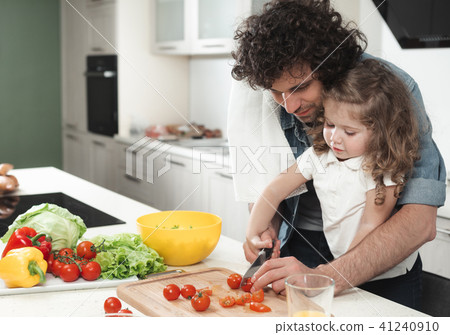 Cheerful father and daughter making salad in kitchen  41240910