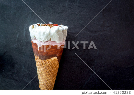 Ice cream strawberry in waffle cone on black Ice cream strawberry in waffle cone on black 41250228