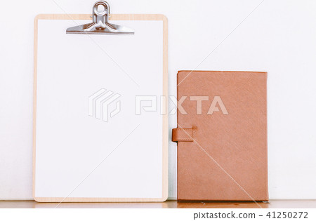 Paper in clipboard and notebook on wooden table 41250272