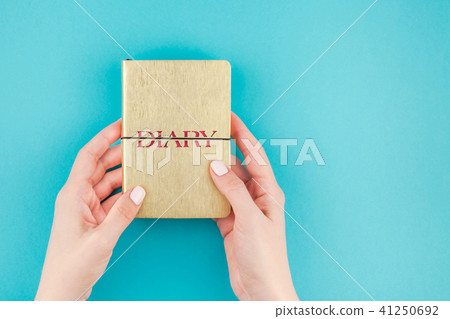 Woman hands holding golden diary Woman hands holding golden diary 41250692