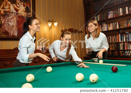 Young women playing billiards at office after work. 41251780