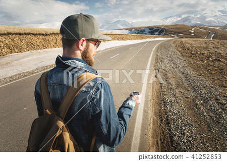 Hipster man using a compass on a snowy mountain 41252853
